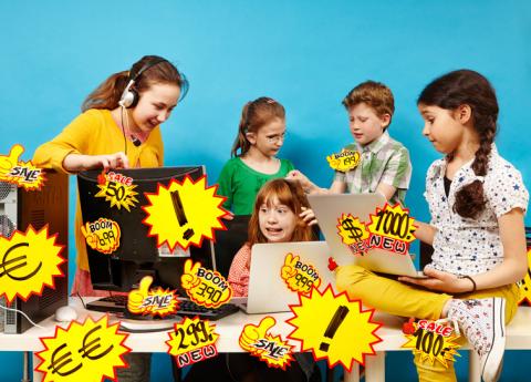 Fünf Kinder vor Computern mit gelben Preisschildern