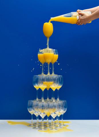 Eine Flasche Orangensaft füllt eine Gläserpyramide