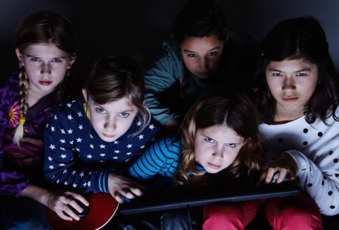 5 Mädchen blicken düster drein und halten dabei eine Tastatur