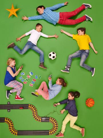 Sechs Kinder spielen Fußball, Karten und Rennautobahn