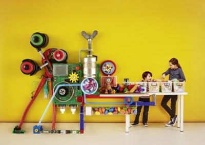 Zwei Kinder und eine witzige Maschine mit Transportband wie im Supermarkt