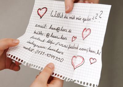 Kinderhände übergeben einen Zettel mit Frage und persönlichen Daten